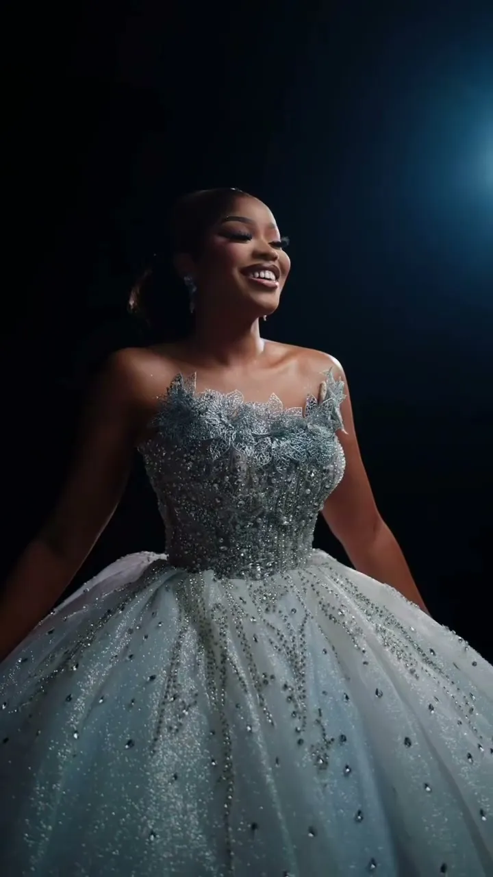 An ice-blue beaded ball gown on a dark set